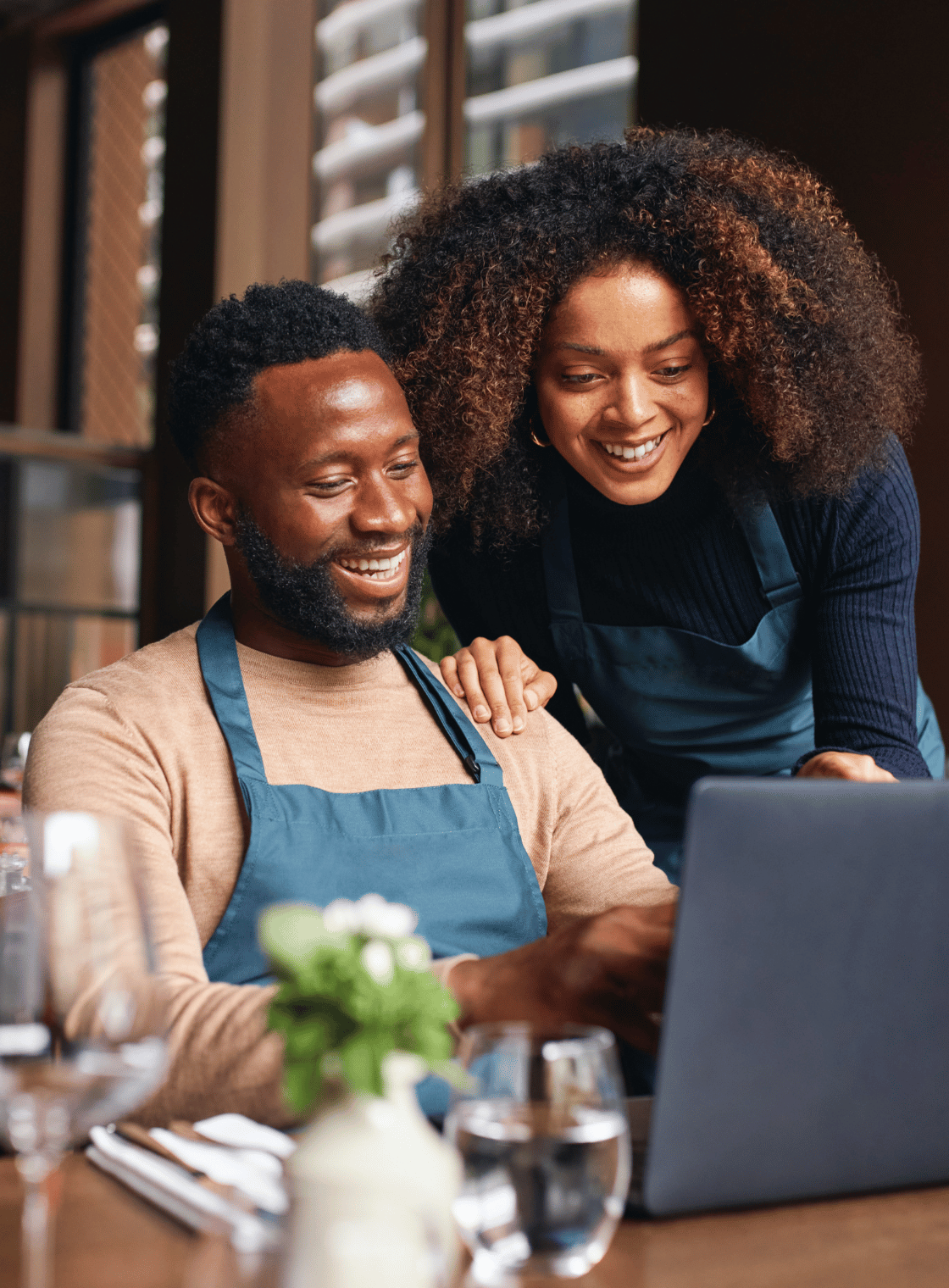 Happy business owner and colleague collaborating on a laptop in a modern workspace, emphasizing teamwork and digital marketing solutions at SharpShell Digital.