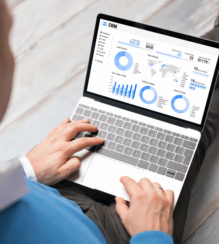 Person using a laptop displaying CRM dashboard with analytics, visualizing customer data and engagement metrics, emphasizing the importance of CRM systems for business efficiency and customer relationships.
