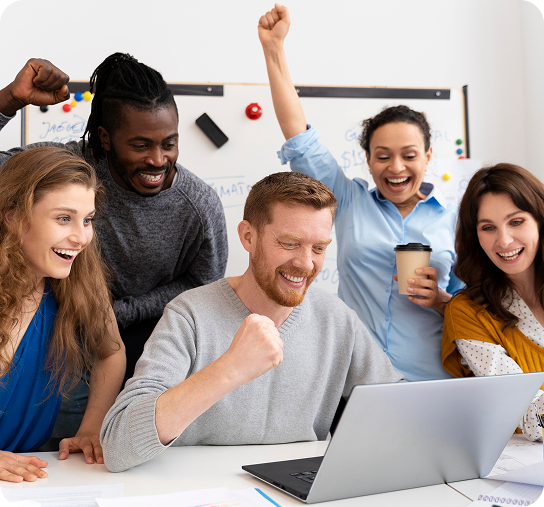 Group of diverse professionals celebrating success around a laptop, reflecting teamwork and achievement in digital marketing and business automation at SharpShell Digital.