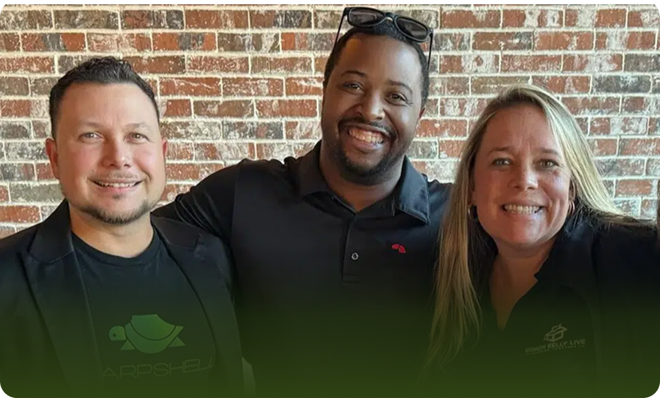 Three SharpShell Digital team members smiling together, showcasing a collaborative spirit in a casual setting with a brick wall background, emphasizing their commitment to client engagement and excellence in digital marketing.