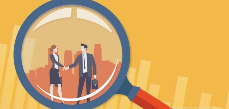 Business professionals shaking hands under a magnifying glass, symbolizing acquisitions and partnerships in the digital marketing landscape.